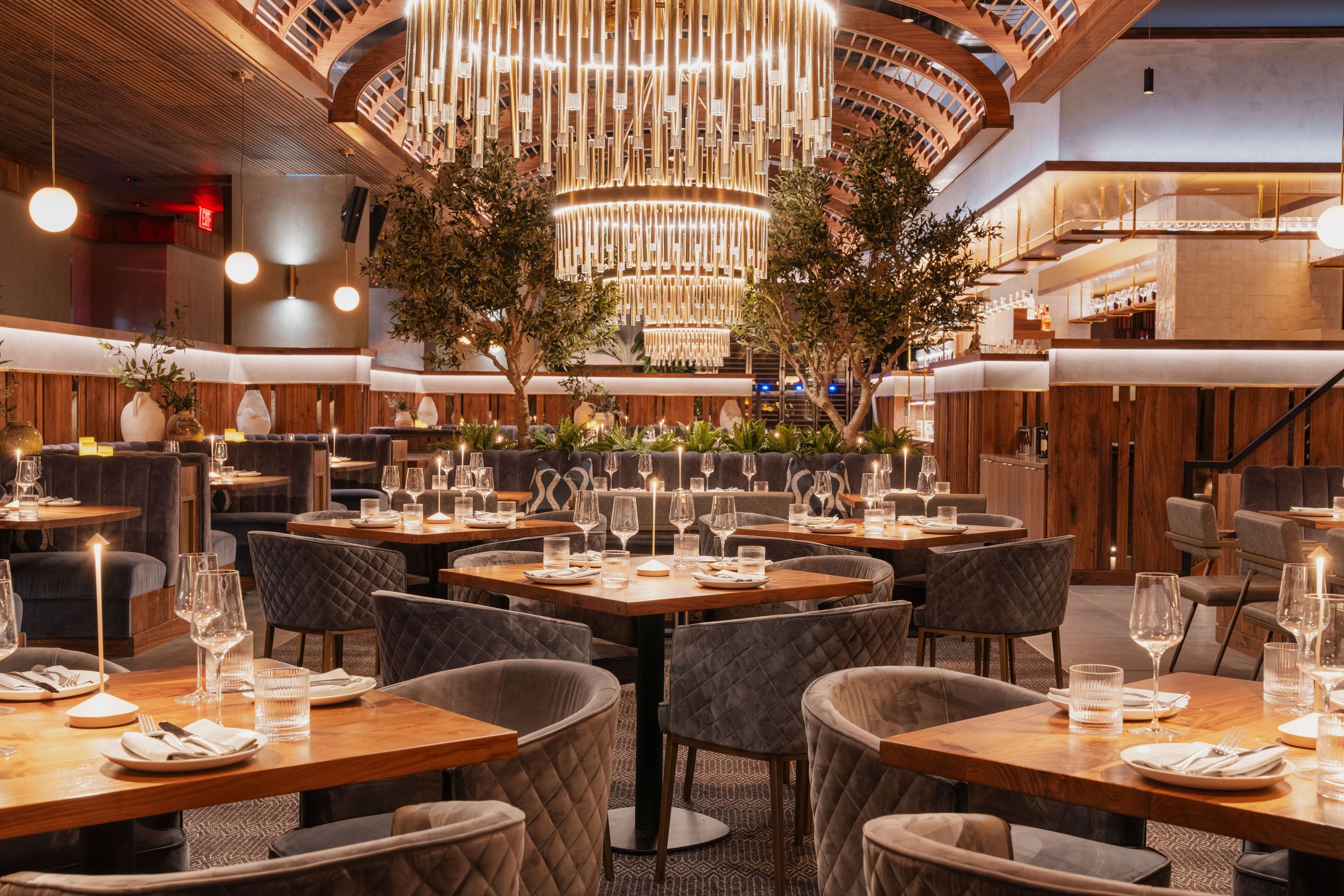 Sparrow Italia Miami featuring cozy seating with wooden tables and elegant chandeliers in a modern dining room.